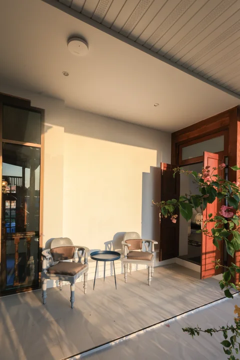 Private corner terrace seating with two antique armchairs, small table and climbing roses