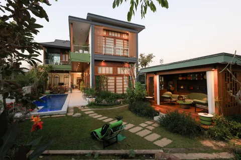 Villa exterior at dusk from the garden showing pool, stepping stones, sala and frangipani tree